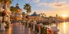 Visitors approach an unbranded vintage Florida boardwalk entertainment venue in warm morning light.
