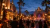 Visitors enter an unbranded Florida theme-park entertainment district decorated for a seasonal nighttime event.