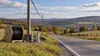 A rural Pennsylvania road with utility poles and fiber-optic equipment prepared for broadband expansion.