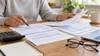 AI-generated illustration of a person comparing generic health-plan documents; not a photograph of Rhode Island officials, insurers, or a current event.