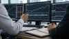 Os analistas de investimento analisam os dados do mercado obrigacionista numa mesa de operações profissional.