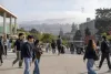 Students walk through a foggy urban public university campus in San Francisco.