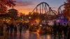 Visitors walk through a generic Georgia amusement park decorated for a fall Halloween evening.