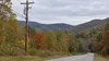 AI-generated illustration of electricity distribution poles in autumn hills; not the Mitchell plant or a specific Kentucky location.