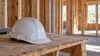 AI-generated illustration of generic timber framing and an unmarked hard hat; not a plaintiff’s property or a specific Minnesota project.