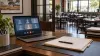 AI-generated illustration of a laptop and paperwork in a restaurant office; not an actual TABC hearing or licensed business.