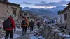 AI-generated editorial visualization of rescue workers walking through an earthquake-damaged high-altitude village in Tibet.