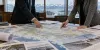 Policy staff review an Alaska natural gas pipeline map in a government meeting room