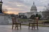 Dalawang bakanteng upuang kahoy ang magkaharap sa labas ng US Capitol noong madaling araw.