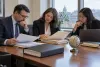 University compliance professionals review anonymized foreign-funding records in a Washington office.