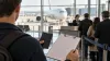 AI-generated illustration of a traveler holding a blank form and closed passport at an international airport departure gate