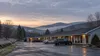 Editorial illustration of a quiet Vermont roadside motel at cold dawn, used as a general representation of temporary lodging.