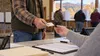 Editorial illustration of an anonymous voter presenting identification at a generic early-voting check-in table in an Appalachian community center.