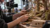 AI-generated illustration of a craftsperson adjusting an original bird puppet beside a miniature forest set; not a photograph of LAIKA’s production.
