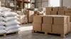 AI-generated illustrative image of plain food parcels and sacks in a humanitarian warehouse, not a photograph of a Gaza aid operation.
