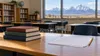 Illustrative empty Wyoming classroom with books and blank assessment papers on a desk