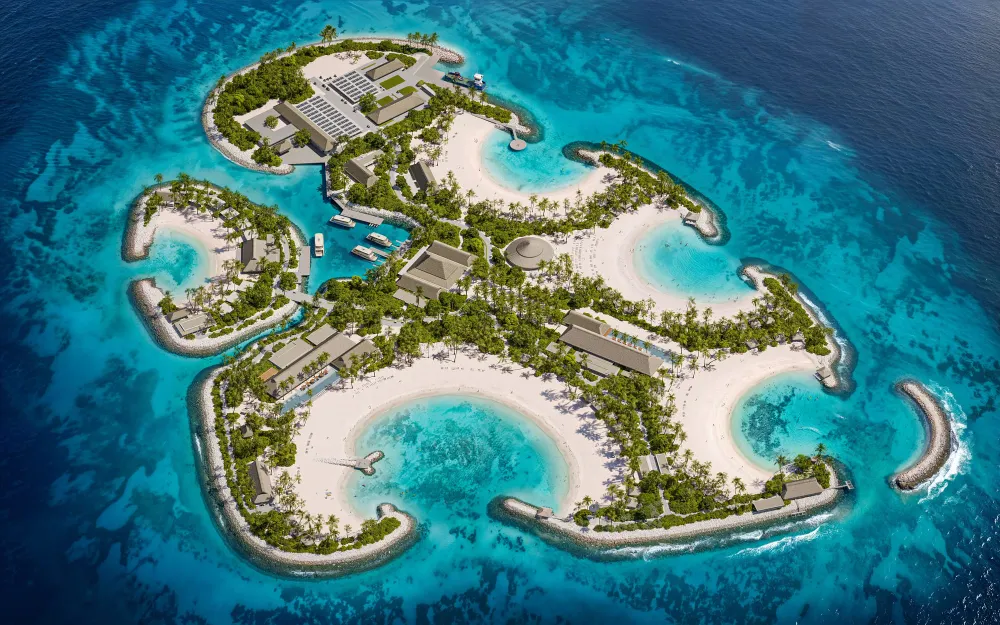 Aerial rendering of Sandy Cay showing curved white-sand beaches, turquoise coves, palm trees, and buildings across the island.
