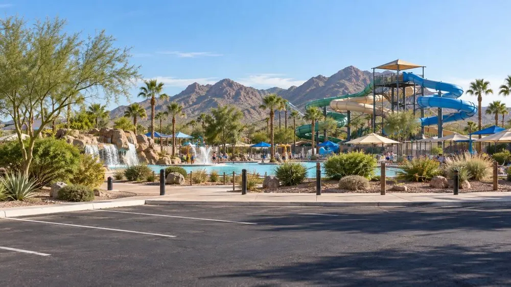A generic Arizona desert water park with slides, a pool and an open parking area under clear morning light.