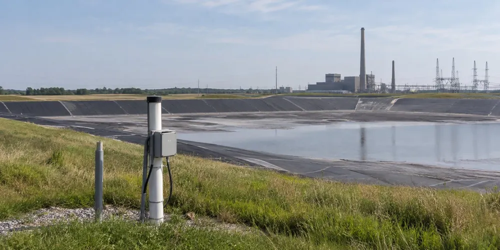 Conceptual editorial image of a lined coal-ash basin with monitoring equipment and a distant power plant