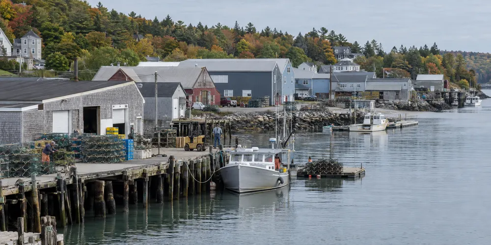 A working waterfront with warehouses and small boats in coastal Maine
