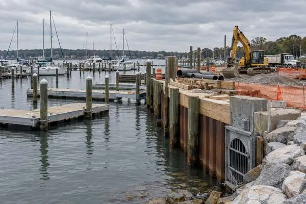 An illustrative marina construction site with floating docks, bulkhead work, drainage components and moored boats.