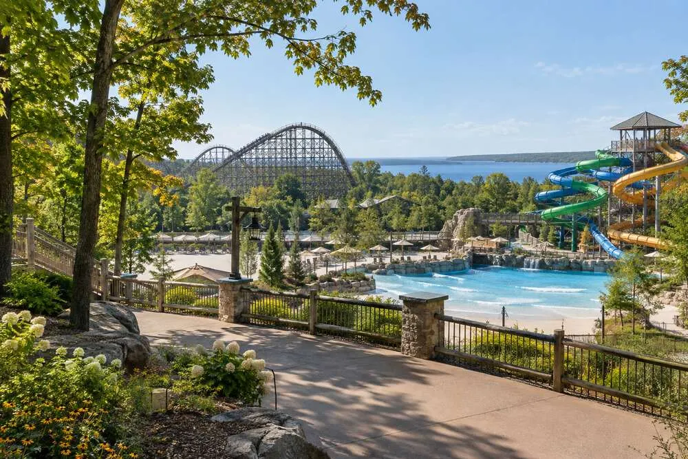 Conceptual wooded amusement park with a roller coaster, water slides and wave pool in a Great Lakes setting