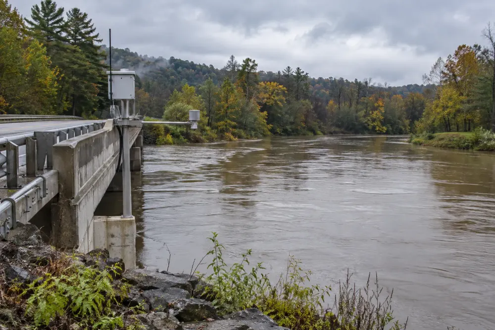 River and stream-monitoring equipment beside a bridge after rainfall