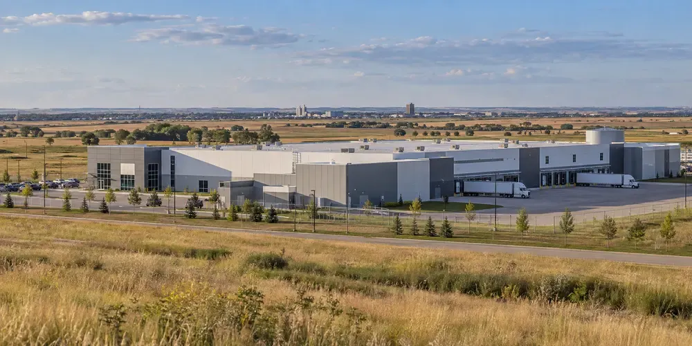 A generic distribution and light-manufacturing complex beside open prairie, illustrating North Dakota commercial activity.
