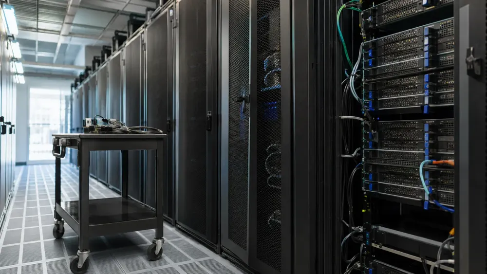Racks para servidores sin marca y un carrito para equipos sin adornos en un centro de datos moderno con iluminación natural