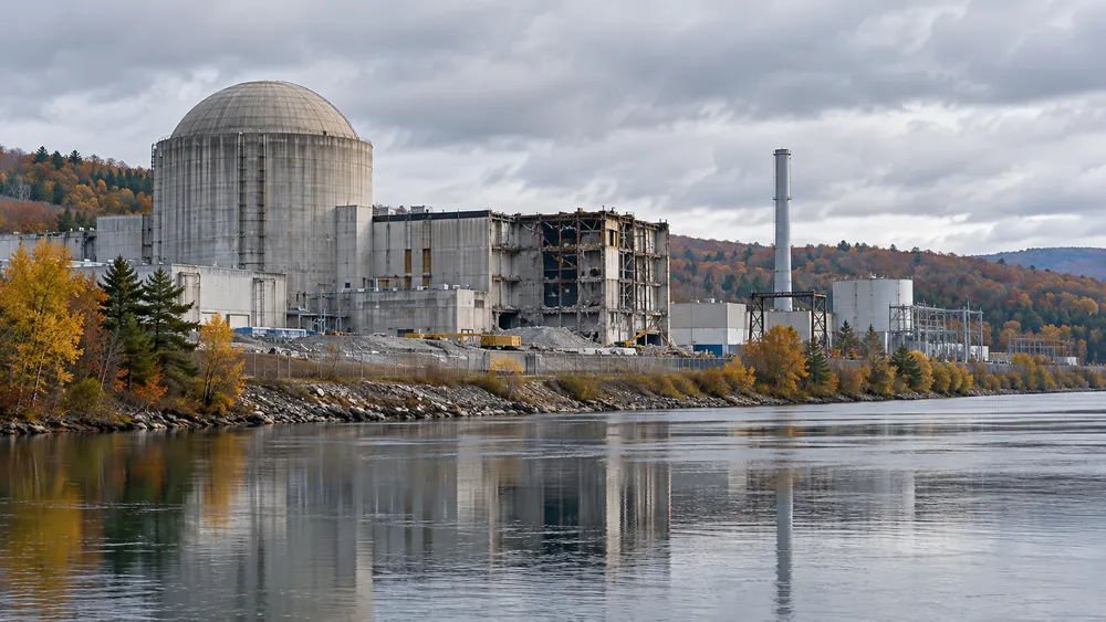 Conceptual editorial image of a decommissioned industrial energy facility beside a river in Vermont.