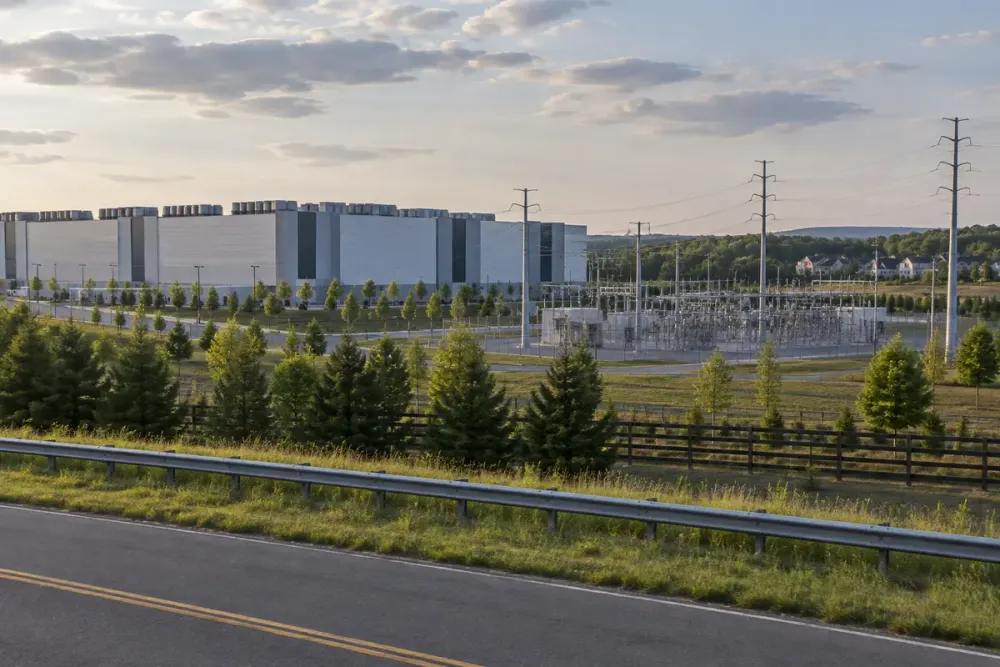 Large data center campus, electrical substation and nearby homes viewed from a Virginia roadside
