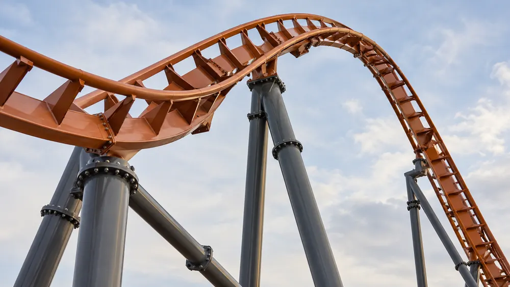 AI-generated illustration of generic steel roller-coaster track against the sky; not a photograph of Goliath or the incident.