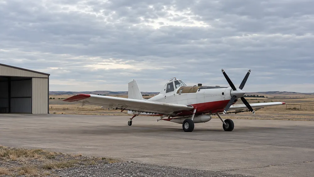 AI-generated editorial illustration of an unmarked single-engine firefighting aircraft on a rural prairie airfield; not the actual Wall base or a documented event.