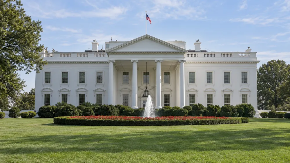 AI-generated illustrative view of the White House exterior in neutral daylight; not a photograph of the sanctions announcement.