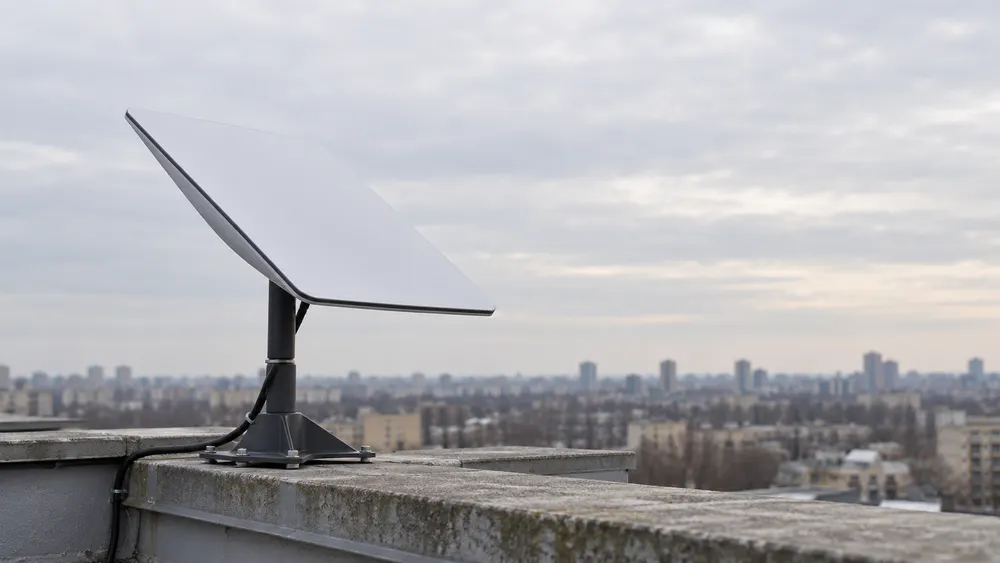 AI-generated contextual image of an unbranded flat-panel satellite terminal on a rooftop; not a photograph of equipment involved in Ukraine’s reported service restrictions.