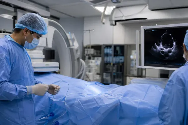 Clinical team preparing for a minimally invasive catheter-based heart-valve procedure in an unbranded hospital suite