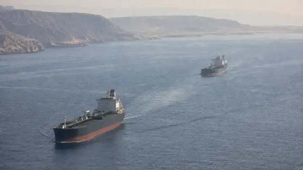 Two unbranded commercial tankers travel through the Strait of Hormuz in natural morning haze