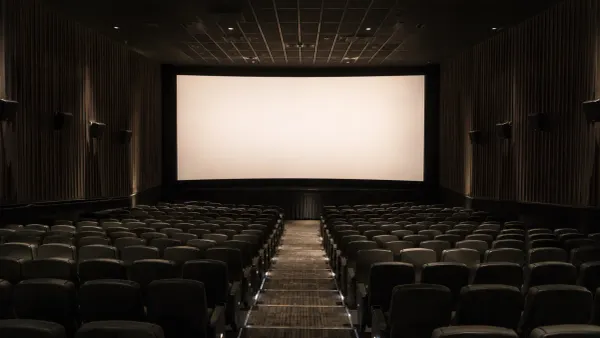 Rows of empty seats facing a blank screen in a modern premium cinema auditorium