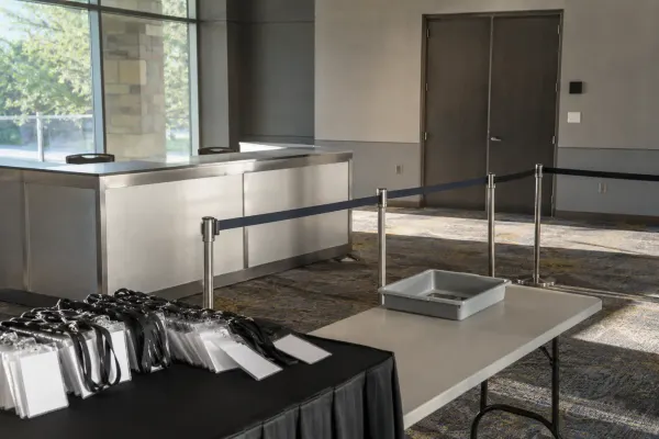 An empty media credential checkpoint inside a naturally lit conference venue