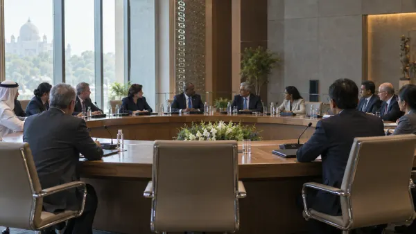 Delegados internacionales celebran una reunión diplomática en torno a una mesa de conferencias circular en un recinto…