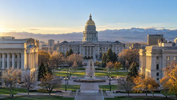 Illustrative view of the Colorado State Capitol and surrounding civic buildings in early morning light.