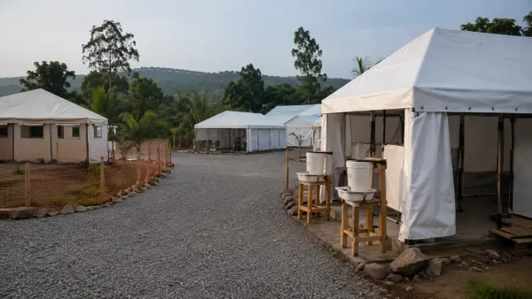 Tiendas de campaña vacías destinadas a la atención médica temporal y estaciones para lavarse las manos en un centro de salud rural, bajo la suave luz de la mañana