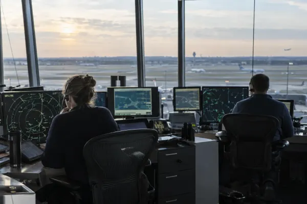 Air-traffic controllers monitoring radar displays in a generic airport control room