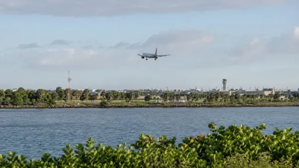 Avión de pasajeros genérico acercándose a un aeropuerto costero sin nombre de Florida, al otro lado de un curso de agua, bajo la luz natural de la mañana