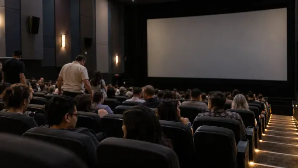 Moviegoers take their seats in a modern multiplex auditorium before a screening