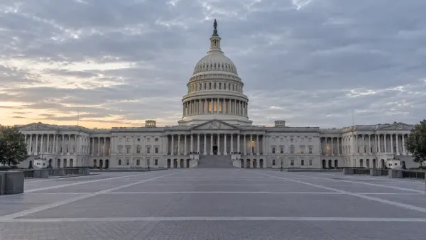 The U.S. Capitol viewed from an empty plaza under soft morning light.