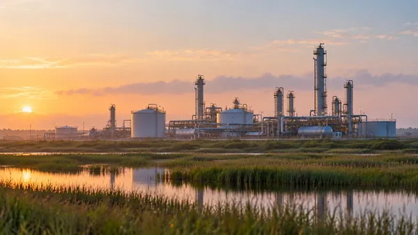 Generic natural-gas processing infrastructure beside Gulf Coast wetlands at sunrise