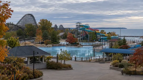Generic lakeside amusement park with a wooden roller coaster and water slides during the off-season