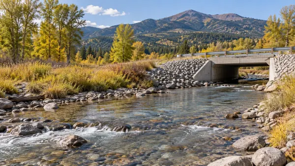 A generic Montana mountain stream flowing beneath a small unmarked public bridge in early autumn.