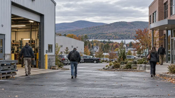 Workers approach a small New Hampshire commercial district on an overcast early autumn morning.